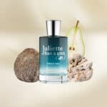 Juliette Has a Gun Pear Inc. perfume bottle with natural pear and rock elements in the background.