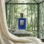 Kilian Black Phantom fragrance bottle with green foliage and a decorative bowl.