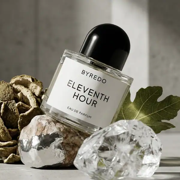 Byredo Eleventh Hour fragrance bottle with decorative rocks and a leaf.