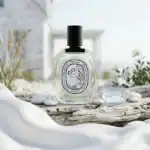 DIPTYQUE Do Son fragrance bottle with black cap on driftwood.