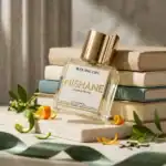 Elegant Nishane perfume bottle with gold cap, surrounded by books and botanical accents.