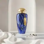 A. MERCHANT OF VENICE fragrance bottle with elegant gold cap and intricate blue pattern, perfect for.