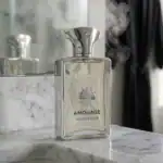 Chic image of Amouage Reflection perfume with clear glass bottle and silver accents on marble.