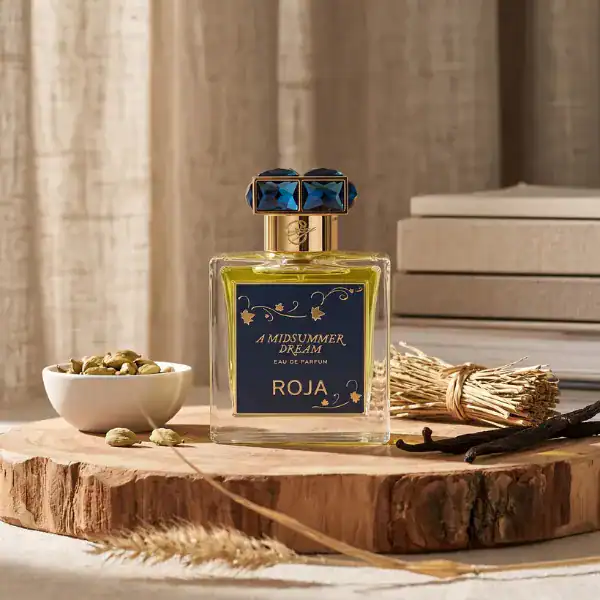 Elegant perfume bottle with blue and gold accents, set on a rustic wooden surface with natural eleme.