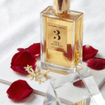 Rosendo Mateu Neroli Iris White Musk perfume bottle with red rose petals and white flowers.