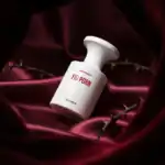 Fig Porn perfume bottle with bold red text on a luxurious satin background.