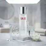 SK-II Facial Treatment Clear Lotion bottle with silver cap on marble tray in bathroom setting.