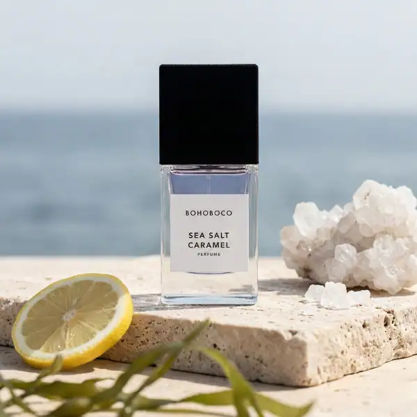Bohoboco Sea Salt Caramel fragrance bottle with lemon slice and white mineral rock on a seaside back.