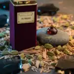 Gritti Privé Florian perfume bottle with a gemstone on a rock, surrounded by botanical elements.