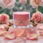 Nuxe skincare - Rose lip balm in a luxurious jar with rose petals background.