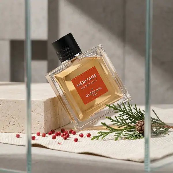 Guerlain Heritage Eau de Toilette fragrance bottle with red label and black cap.