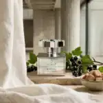 Almaz by Kajal fragrance bottle with blackcurrant and green leaves.