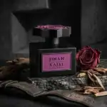 Kajal Jihan perfume bottle with a deep pink rose on a dark textured background.