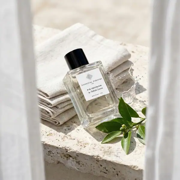 Nobile 1942 Eau Infusion perfume bottle with minimalist design, placed on a stone surface with green.