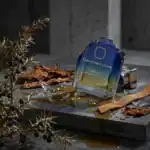 Ormonde Jayne Verano fragrance bottle with dried leaves and natural elements.