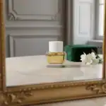 Mimosa Latte fragrance by Alwa in a sleek glass bottle with white cap, accompanied by a green gift b.