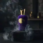 Egoist Mugler perfume bottle with purple velvet texture and gold cap, surrounded by smoky ambiance.