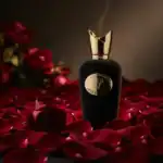 Opera perfume bottle with elegant black design and gold cap, surrounded by rose petals for a romanti.