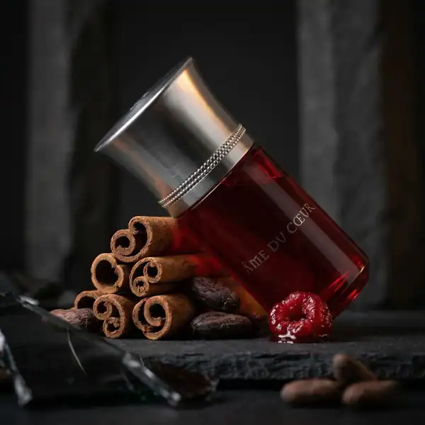 Ame du Cèdre fragrance bottle with cinnamon sticks and spices.
