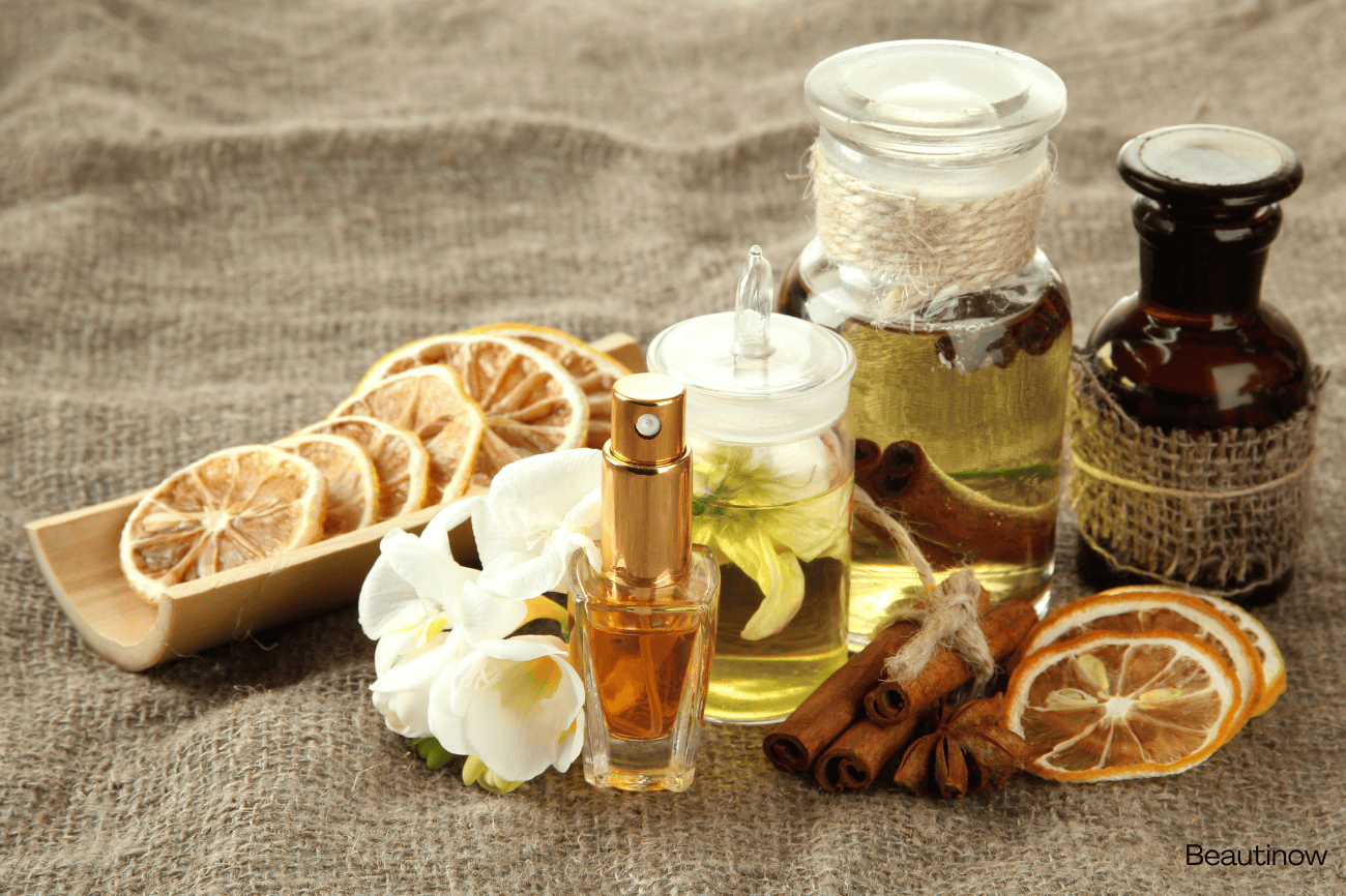Alwa luxury perfume collection with dried citrus slices, cinnamon sticks, and essential oils.