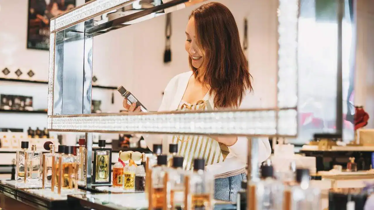 Elegant woman shopping for niche perfumes at a luxury boutique.