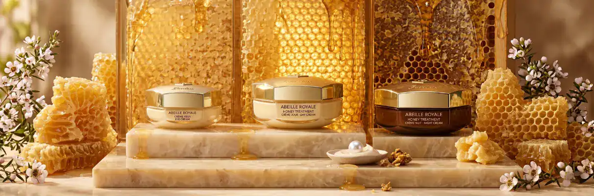 Elegant honey-based skincare jars with beeswax and floral decorations.