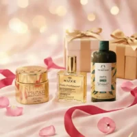 Assorted high-end skincare and haircare products with gift boxes and rose petals.