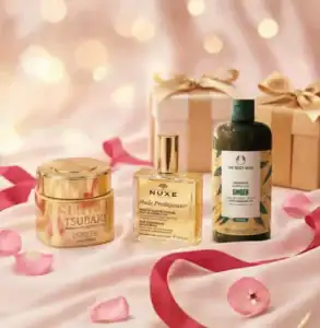 Assorted high-end skincare and haircare products with gift boxes and rose petals.