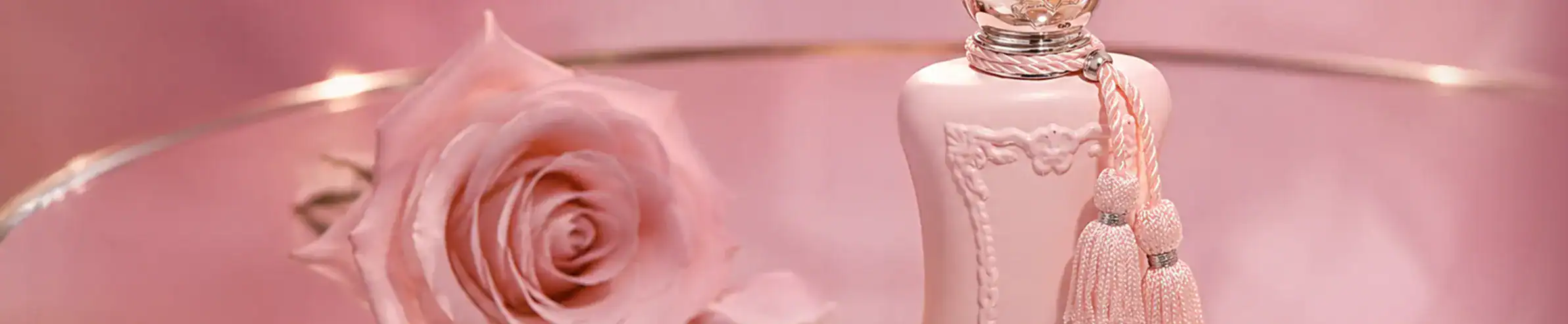 Luxury pink perfume bottle with a delicate tassel and a soft pink rose.