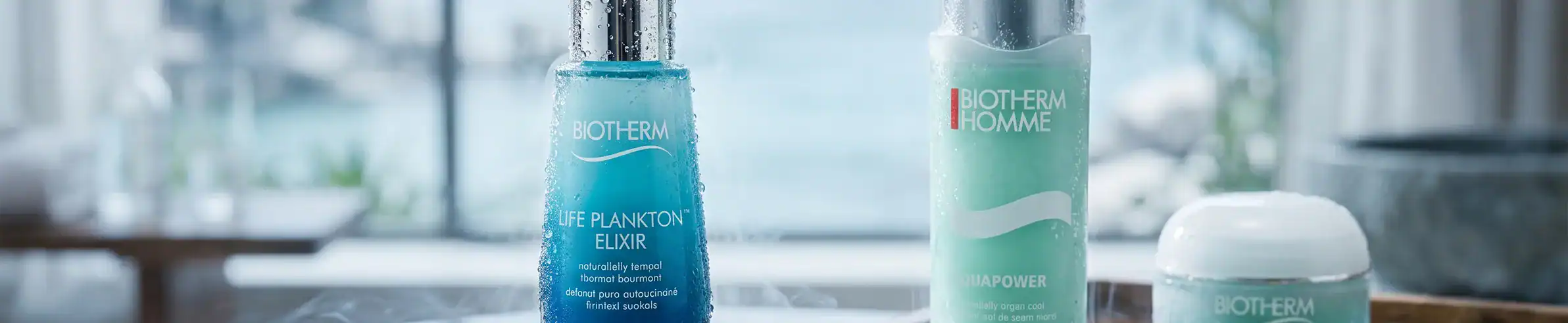 Skincare bottles including Plankton Elixir and other high-end products on a bathroom surface.