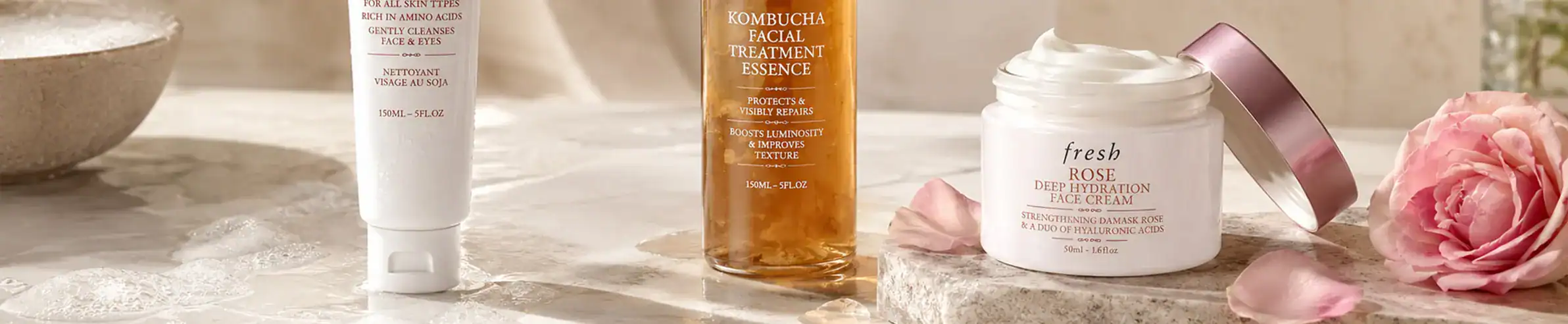 Elegant skincare collection featuring rose-infused creams and serums in sophisticated containers.