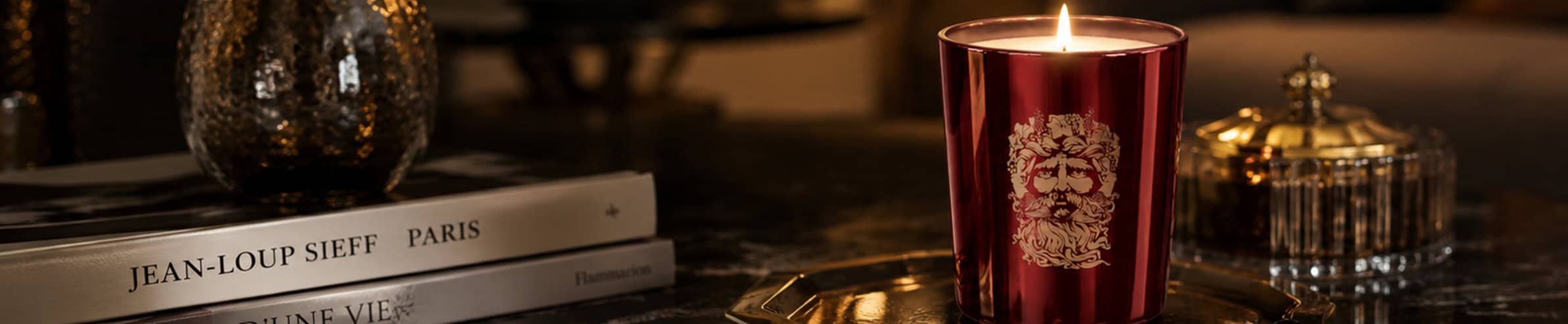 Luxurious red candle with gold emblem, perfect for elegant decor and ambiance.