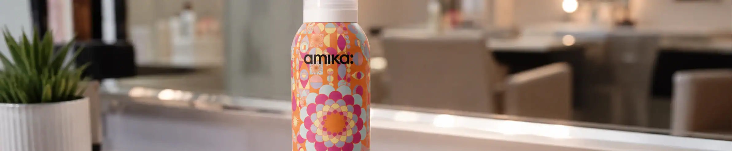 Amika hair care product in a colorful floral bottle for luxury hair styling.